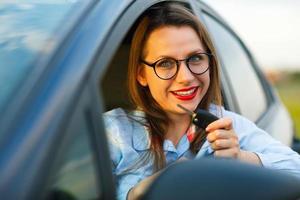 jung ziemlich Frau Sitzung im ein Auto mit das Schlüssel im Hand foto