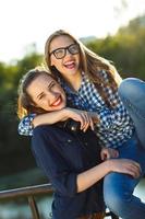 zwei spielerisch jung Frauen haben Spaß draußen foto