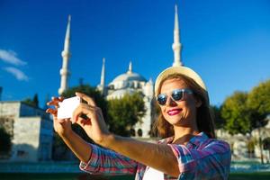 Mädchen Herstellung Selfie durch das Smartphone auf das Hintergrund von das Blau Moschee, Istanbul. Truthahn foto