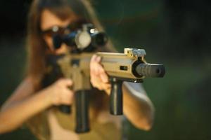 jung weiblich Soldat mit Maschine Gewehr foto