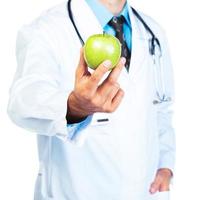 Arzthand, die eine frische grüne Apfel-Nahaufnahme auf Weiß hält foto