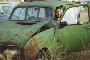 jung gut aussehend stilvoll Mann, tragen Hemd und Krawatte mit alt Autos foto