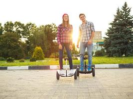 ein jung Paar Reiten Hoverboard - - elektrisch Roller, persönlich Öko Transport, Kreisel Roller, Clever Balance Rad foto