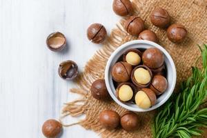 oben Aussicht von trocken geröstet Macadamia Nuss im Weiß Tasse auf Holz Hintergrund, foto