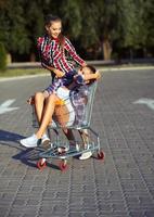 zwei glücklich schön Teen Mädchen Fahren Einkaufen Wagen draußen foto