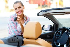 Frau Stehen in der Nähe von ein Cabrio mit Schlüssel im Hand - - Konzept von Kauf ein benutzt Auto oder ein Vermietung Auto foto