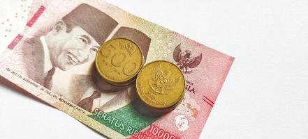 Neu indonesisch Banknoten problematisch im 2022 entlang mit indonesisch Gelb Münzen. Rupiah Währung Konzept isoliert auf Weiß Hintergrund foto