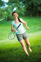 lächelnd Mädchen mit ein Schläger zum ein Badminton im das Park foto