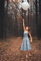 Mädchen mit ein Ballon im das Wald foto