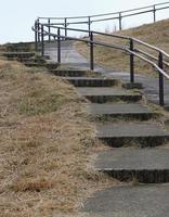 Treppe gemacht von Stein und ein Metall Geländer führen nach oben foto