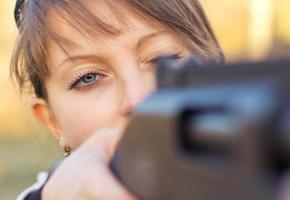 jung Mädchen mit ein Gewehr zum Falle Schießen foto