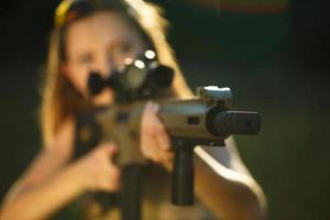 Mädchen mit ein Gewehr zum Falle Schießen Zielen beim ein Ziel foto