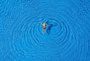 Frau, die auf dem Pool schwimmt foto