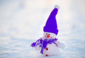glücklicher Schneemann, der in der Winterweihnachtslandschaft steht foto