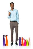 glücklich afrikanisch amerikanisch Mann mit Einkaufen Taschen und halten Anerkennung Karte auf Weiß foto