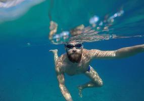 jung Bart Mann mit Maske Tauchen im ein sauber Wasser foto