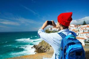 Frau mit ein Rucksack macht ein Foto auf das Smartphone von ein schön Panorama