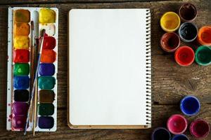 Papier, Aquarelle und Farbe Bürste auf hölzern Hintergrund foto