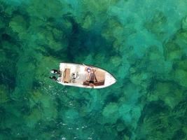 Antenne Umfrage von ein Paar auf ein Boot Sonnenbaden zusammen auf ein warm Sommer- Tag foto