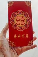 Hand halten rot Briefumschlag Geschenk Chinesisch Neu Jahr foto