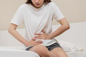 Blähung Geschwür, asiatisch jung Frau, Mädchen Hände im Bauch, Magenschmerzen von Essen Vergiftung, Bauch Schmerzen und Verdauungs- Problem, Gastritis oder Durchfall. Abdomen Entzündung, Menstruation- Zeitraum Personen. foto