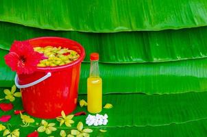 Songkran Festival Hintergrund mit Blumen im Wasser Eimer, duftend Wasser und marly Kalkstein auf nass Banane Blatt Hintergrund. foto