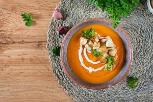 Kürbis Suppe im ein Schüssel serviert mit Petersilie und Croutons. vegan Suppe. das Erntedankfest Tag Lebensmittel. Halloween Mahlzeit. oben Aussicht foto