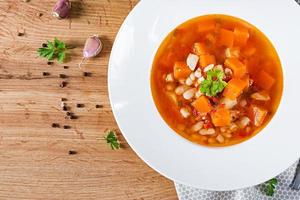 Tomate Hähnchen Suppe mit Kürbis und Weiß Bohnen im Weiß Schüssel. oben Aussicht foto