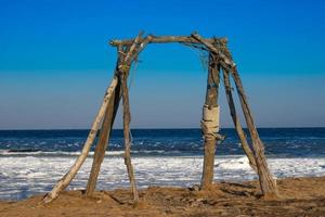 Holzschaukel an einem Strand mit Meer im Hintergrund foto