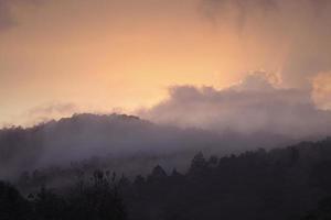 Nebel bedeckt Berg beim Sonnenaufgang foto