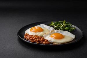 köstlich herzhaft Frühstück bestehend aus von zwei gebraten Eier, Dosen- Linsen und Microgreens foto