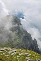 ein steil Cliff bewachsen mit Gras und versteckt durch Wolken