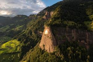 ein enorm schweizerisch Flagge ist Fest auf ein Cliff foto