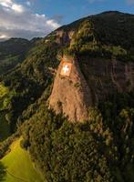 ein enorm schweizerisch Flagge ist Fest auf ein Cliff foto