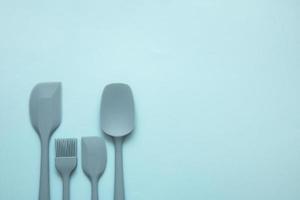 kulinarisch Silikon Spatel von anders Größen und Formen und ein Silikon Bürste auf ein Blau Hintergrund, kulinarisch Hintergrund foto