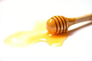 hölzern Honig Schöpflöffel mit Honig Gelb Süss auf Weiß foto