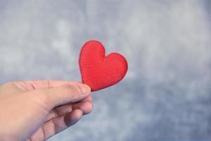 Herz auf Hand zum Philanthropie Konzept - - Mann halten rot Herz im Hände zum Valentinsgrüße Tag oder spenden Hilfe geben Liebe Wärme nehmen Pflege foto