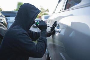 das Dieb ist stehlen ein Auto mit ein Schraubendreher. foto