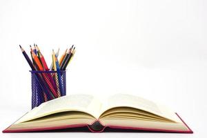 Fokus von Wachsmalstift oder farbig Bleistifte im Box und verwischen das öffnen Buch, auf Weiß Hintergrund. Wissen und Bildung Konzept. foto
