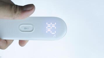 ein Hand halten Digital Thermometer zeigen normal Temperatur mit isoliert auf Weiß. foto