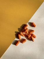 Orange Tabletten auf ein Weiß und Gelb Hintergrund foto