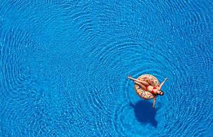 Frau, die auf dem Pool schwimmt foto