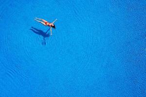 Frau, die auf dem Pool schwimmt foto