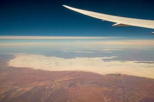 Wolken und Himmel wie gesehen durch Fenster von ein Flugzeug. fliegen über das Wüste Center von australisch Hinterland, Nord Gebiet Zustand von Australien. foto