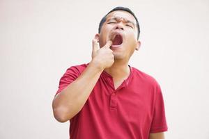 asiatisch Mann leidet von Zahnschmerzen von Essen Schrott foto