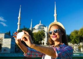 Mädchen Herstellung Selfie durch das Smartphone auf das Hintergrund von das Blau Moschee, Istanbul. Truthahn foto