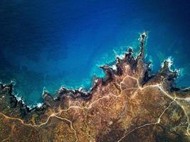 oben Aussicht von ein verlassen Küste. felsig Ufer von das Insel von Teneriffa. Antenne Drohne Aufnahmen von Meer Wellen erreichen Ufer foto