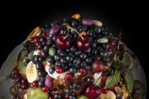 Teil von ein schön Kuchen dekoriert mit verschiedene Beeren und Früchte auf ein dunkel Hintergrund. foto