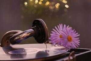 luxuriös retro Grammophon mit ein Vinyl Aufzeichnung mit ein romantisch Strauß von Blumen. foto