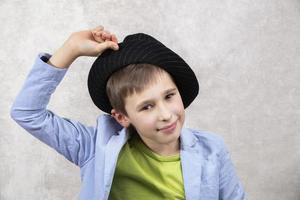 Porträt von ein Junge mit ein Lächeln im ein elegant Hut und Blau Jacke. modisch Kind. foto